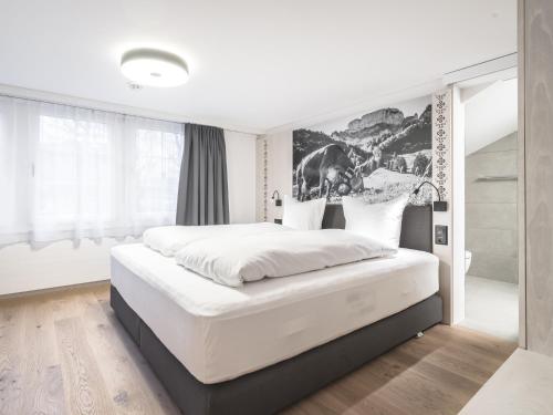 a bedroom with a large white bed in a room at Traube Restaurant & Hotel in Appenzell
