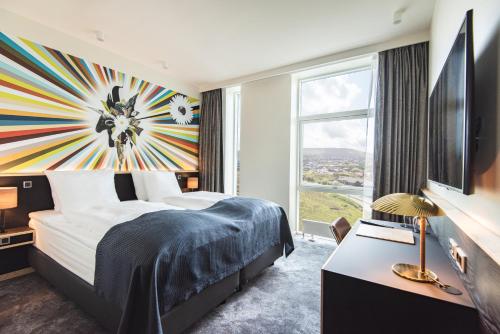 a hotel room with a bed and a large window at Hotel Brandan in Tórshavn