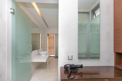 uma casa de banho com um lavatório, um chuveiro e um espelho. em GeorgeTown PrivatePool Snooker 20Pax BBQ em George Town