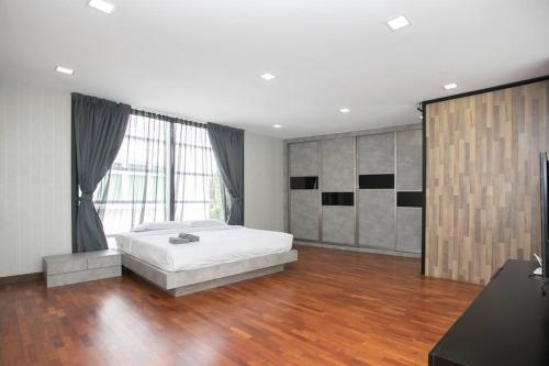 een slaapkamer met een wit bed en een houten vloer bij GeorgeTown PrivatePool Snooker 25Pax BBQ in George Town