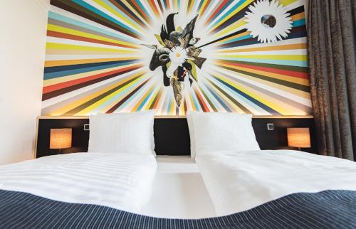 a bedroom with two beds and a colorful wall at Hotel Brandan in Tórshavn