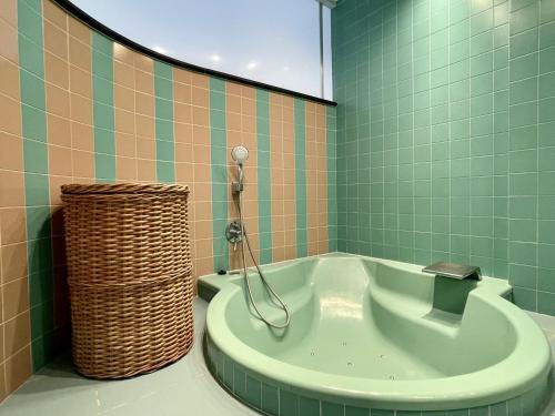 y baño con bañera y azulejos verdes. en La Pineda I 1 3-6, en L'Estartit