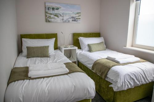 a bedroom with two beds with towels on them at Wave Stays - Ground Floor Apartment in Cleveleys