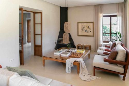 een woonkamer met een salontafel en een open haard bij Premier Villa Rental in Mallorca Es Barranc Vell in Pòrtol