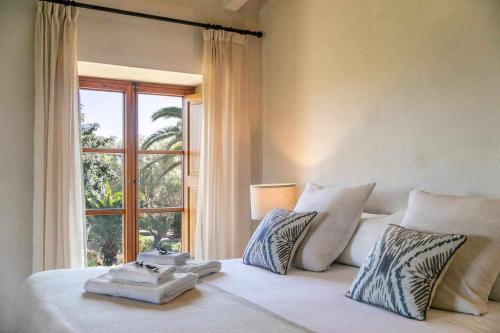 1 dormitorio con 1 cama blanca grande y ventana en Premier Villa Rental in Mallorca Es Barranc Vell, en Pòrtol