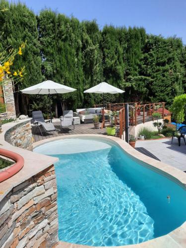 - une piscine dans une cour avec des chaises et des parasols dans l'établissement BORA BORA Maison les palmiers., à Venelles
