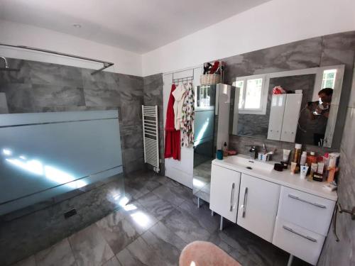 a bathroom with a sink and a mirror at BORA BORA Maison les palmiers. in Venelles