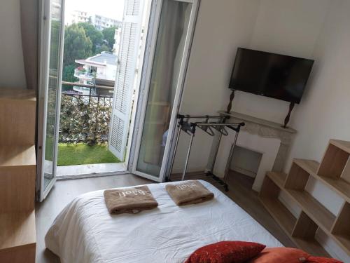 une chambre avec un lit et une télévision à écran plat dans l'établissement Stanislas sea view, à Cannes