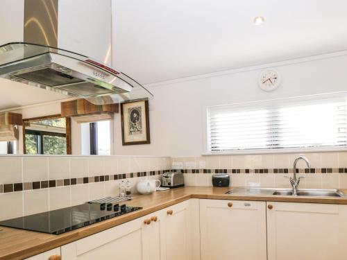 a kitchen with white cabinets and a sink at Manor Farm Lodge in Salisbury