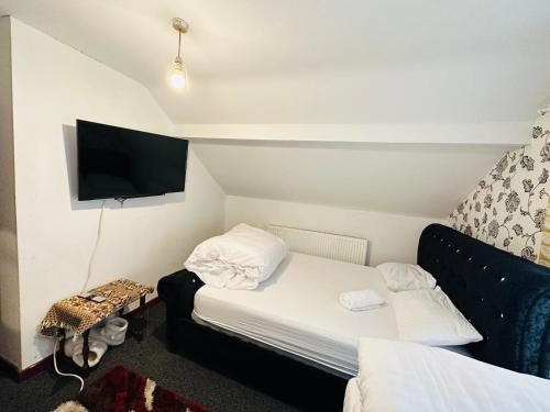 een kamer met 2 bedden en een flatscreen-tv bij Unique private rooms (1) in Bolton