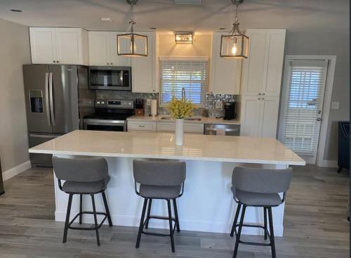 a kitchen with a large island with three bar stools at 3 bedroom 2 bath with hot tub, game room and boat slip in Crystal River