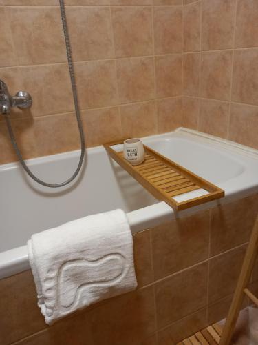een badkamer met een bad, een douche en een handdoek bij Apartman studio MINNA Osijek, free parking in Osijek