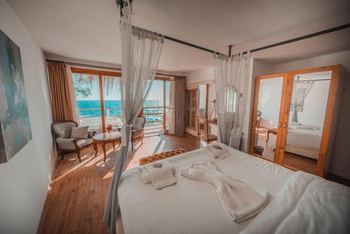 a bedroom with a bed with a view of the ocean at Zakros Hotel Lykia in Faralya