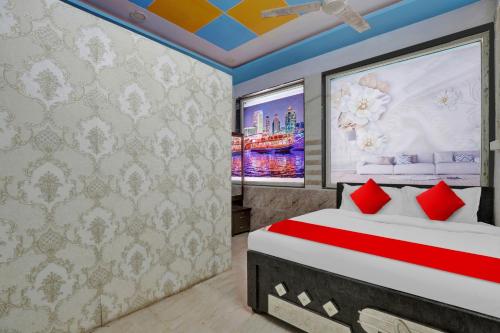 a bedroom with a bed with red pillows at POP Hotel Dk Guest House in Ahmedabad