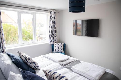 a living room with a bed and a window at Wave Stays - First Floor Apartment in Cleveleys