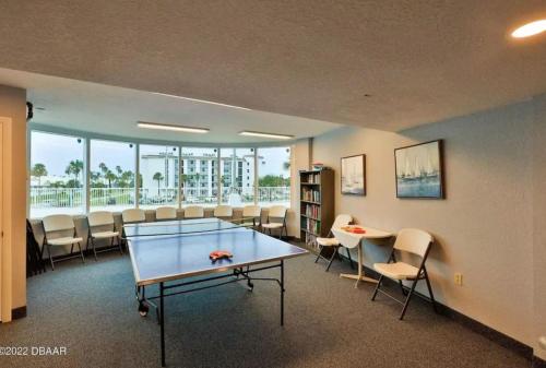 a room with a ping pong table and chairs at 2 Bedroom 2 bath Condo on the Beach on the 8th Floor in Daytona Beach