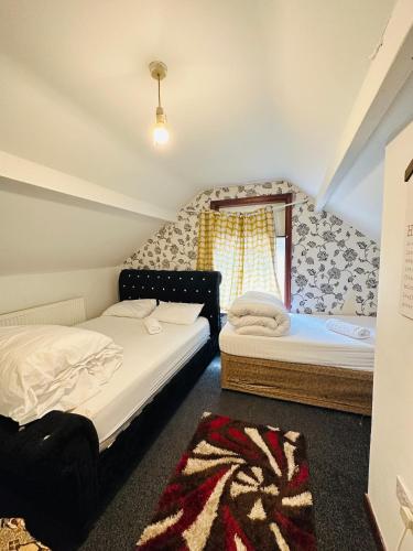 een slaapkamer met 2 bedden en een raam bij Unique private rooms (1) in Bolton