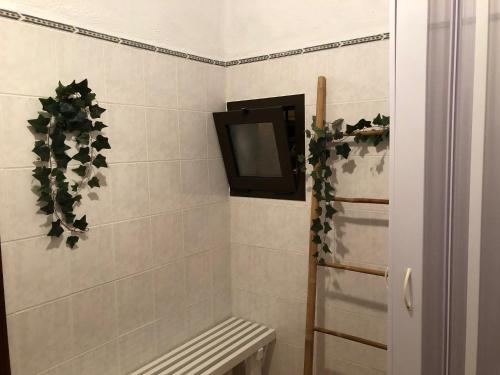 uma casa de banho com uma televisão na parede e um banco em Villa 36 - THE CHARM(E) OF PORCHES em Porches