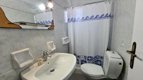 y baño con aseo blanco y lavamanos. en Amarandos Studios - Rooms & Apartments, en Marantochori
