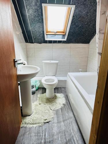 een badkamer met een toilet, een wastafel en een raam bij Unique private rooms (1) in Bolton