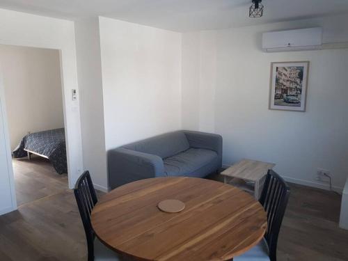 ein Wohnzimmer mit einem Tisch und einem Sofa in der Unterkunft Appartement T2 Saint Malo, Dinard, Dinan et Dol in Miniac-Morvan