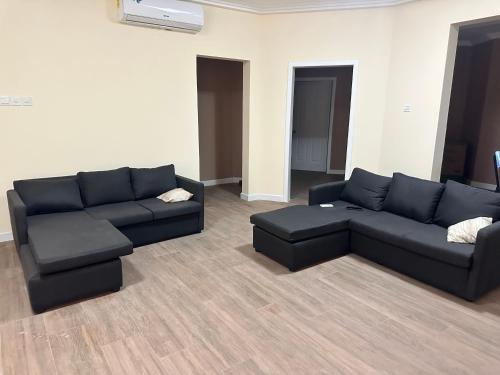 a living room with a black couch and a table at Potsdam Homes in Prampram