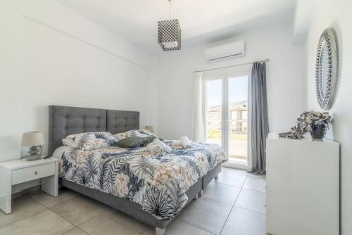 een slaapkamer met een bed en een raam bij Minoas Apt Next to the Beach in Milatos