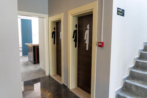 a hallway with three doors with silhouettes of women on them at Eroglu City Hotel in Fethiye