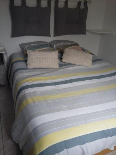 ein Bett mit zwei Kissen darüber in der Unterkunft Le Paradis in Fressies