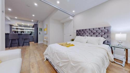ein großes weißes Schlafzimmer mit einem großen Bett und einem Tisch in der Unterkunft Family Modern walkout Basement wSauna Indoor Fireplace Wifi in Innisfil
