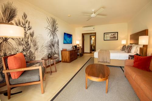 um quarto de hotel com uma cama e uma sala de estar em Sands Suites Resort & Spa em Flic-en-Flac