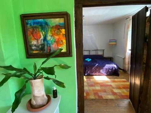 a green room with a potted plant and a bedroom at Landhaus Hideaway Ruheoase Pool in Pirching am Traubenberg