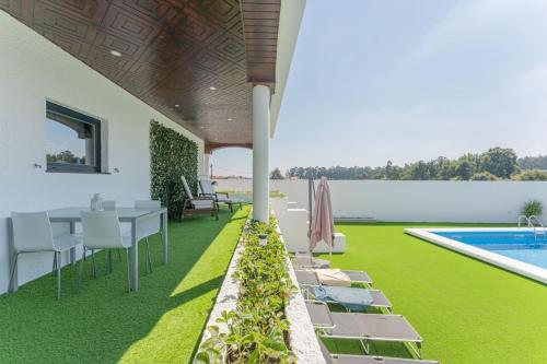 une terrasse avec une table et des chaises ainsi qu'une piscine dans l'établissement Solar dos Alexandres, à Maia