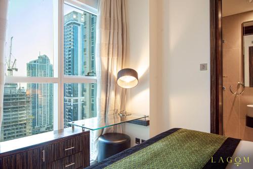 a bedroom with a window with a view of a city at Lagom Vacation Homes 1 & 2 bedroom Apartment in Bonnington Tower, cluster J in Dubai