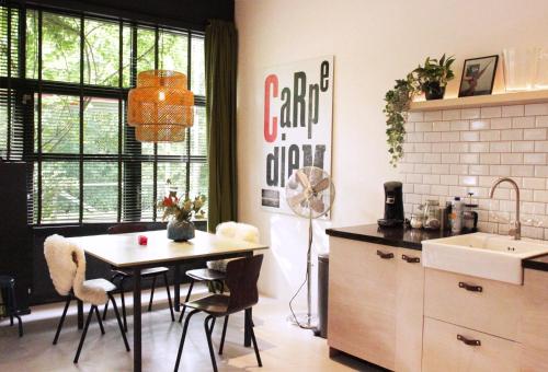 a kitchen with a table and chairs and a sink at The Quay Amsterdam - FREE PARKING in Amsterdam