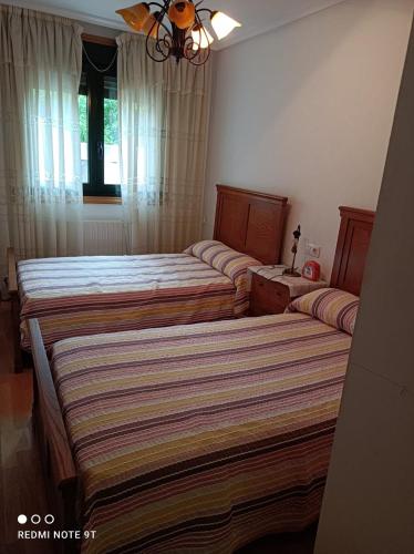 - une chambre avec 2 lits et une fenêtre dans l'établissement apartamento de dos habitaciones en Quiroga, à Quiroga