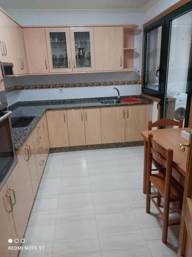 une cuisine vide avec une table et une cuisine dans l'établissement apartamento de dos habitaciones en Quiroga, à Quiroga