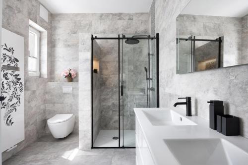 a bathroom with a shower and a sink and a toilet at Vila Mignon in Bled