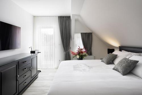 Un dormitorio con una gran cama blanca y una ventana en Vila Mignon en Bled