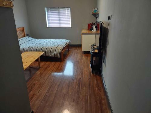 a bedroom with a bed and a wooden floor at Old Eden House in Rossbeg