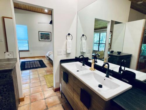 a bathroom with a sink and a large mirror at Jania Boho Chic Retreat in Austin