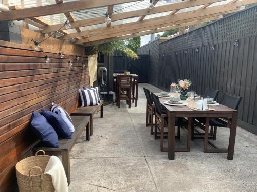 a patio with tables and chairs under a wooden pergola at Quite, quaint & private guesthouse, sleeps 6 in Melbourne
