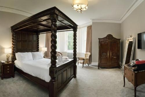 a bedroom with a large canopy bed and a window at Friars Carse Country House Hotel in Dumfries