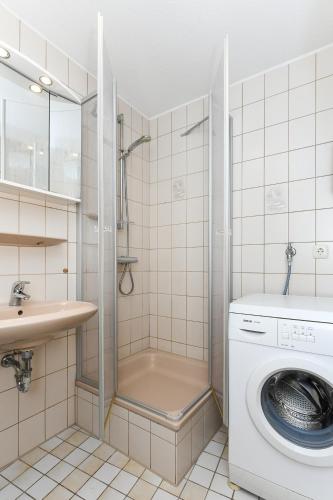 a bathroom with a washing machine and a sink at Ferienwohnung Elly in Esens