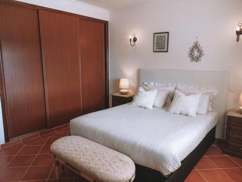 een slaapkamer met een groot bed met witte lakens en kussens bij Green Ville in Faro