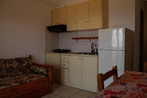a kitchen with a white refrigerator and a table at Ανεμώνη Apartments in Gialiskari