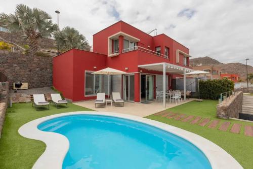 a villa with a swimming pool in front of a house at Sea View Villa Vista Golf in Salobre