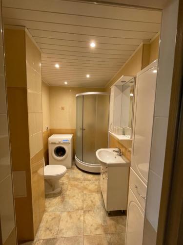 a bathroom with a toilet sink and a washing machine at Ruses. One Bedroom Apartment in Rīga
