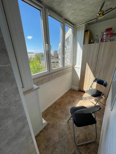 um quarto com duas cadeiras e duas janelas em Ruses. One Bedroom Apartment em Riga