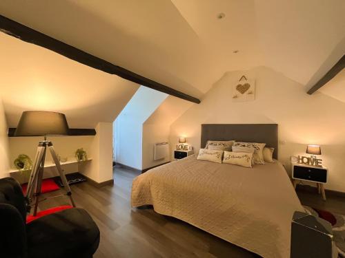 - une chambre avec un lit, une lampe et un tripode dans l'établissement Villa Napoléon, à Pierrefonds